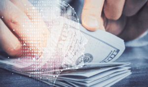 Hologram of a technological brain over the a picture of a person fanning $100 bills. Close up of their hands.